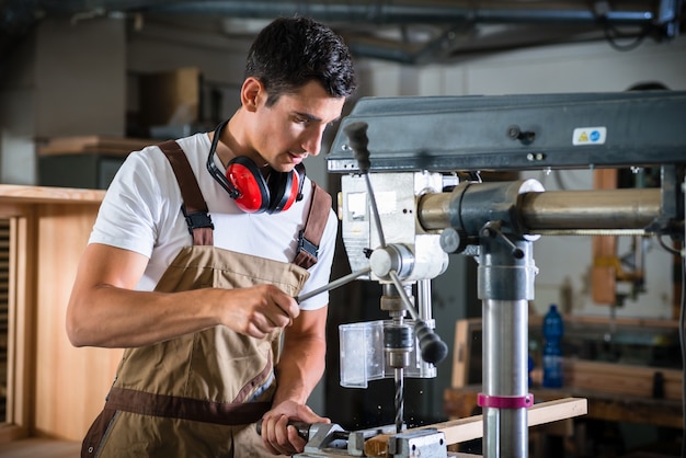 Cabinet maker working on power drill