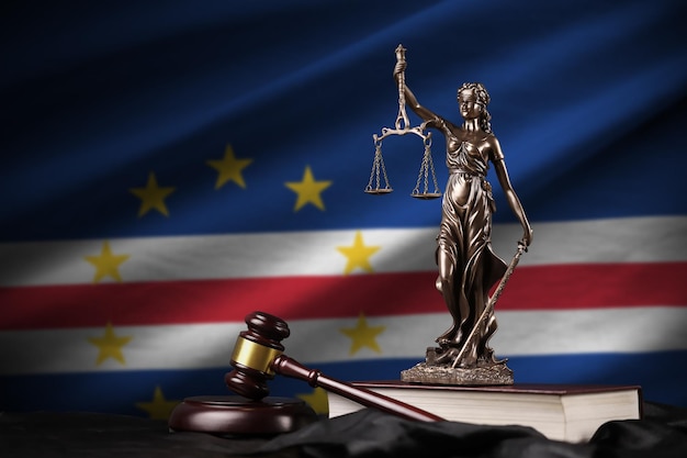 Cabo verde flag with statue of lady justice constitution and judge hammer on black drapery Concept of judgement and guilt