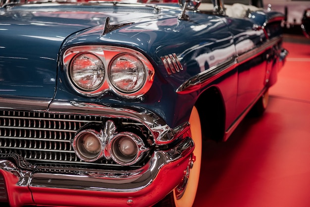 Cabriolet retro car parked indoors on the red tile at automobile exhibition