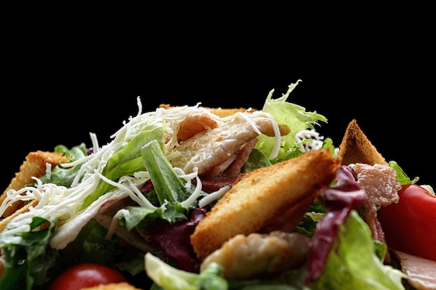 Caesar salad on a black plate Close up