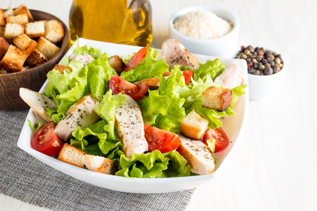 Caesar salad in a white bowl on wooden table