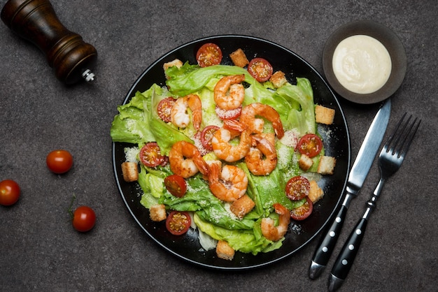 Caesar salad with shrimp, croutons and parmesan, top view