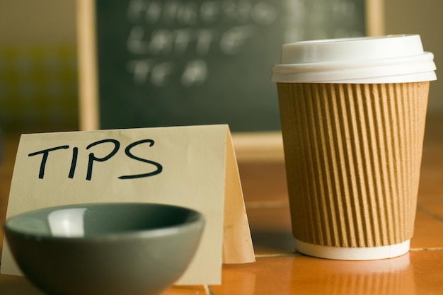 Cafe counter with coffee cup, prices and tip box