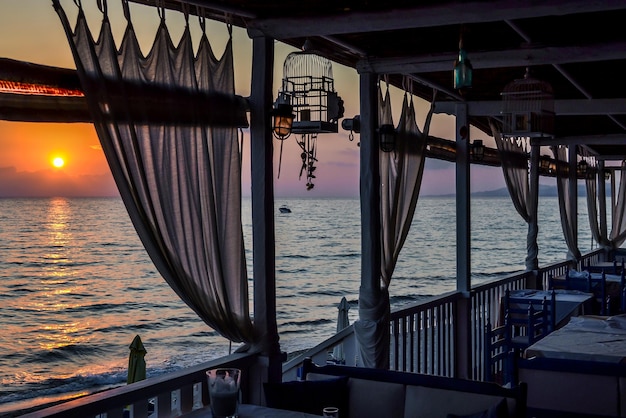 Cafe near the sea of rough planks with curtains at dusk or at dawn