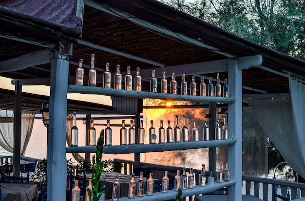 Cafe near the sea of rough planks with a lot of bottles At dusk or at dawn