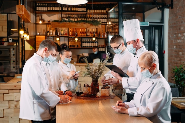 Cafe staff on morning briefing wearing protective masks.