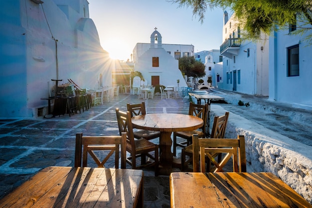 Cafe table in picturesque streets of Mykonos Chora town in famous tourist Mykonos island Greece