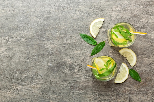 Caipirinha Mojito cocktail vodka or soda drink with lime mint and straw on table background Refreshing beverage with mint and lime in glass top view flat lay