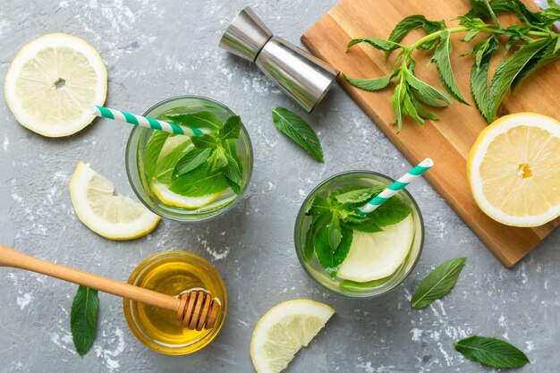 Caipirinha Mojito cocktail vodka or soda drink with lime mint and straw on table background Refreshing beverage with mint and lime in glass top view flat lay