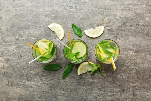 Caipirinha Mojito cocktail vodka or soda drink with lime mint and straw on table background Refreshing beverage with mint and lime in glass top view flat lay