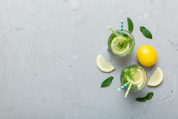 Caipirinha Mojito cocktail vodka or soda drink with lime mint and straw on table background Refreshing beverage with mint and lime in glass top view flat lay