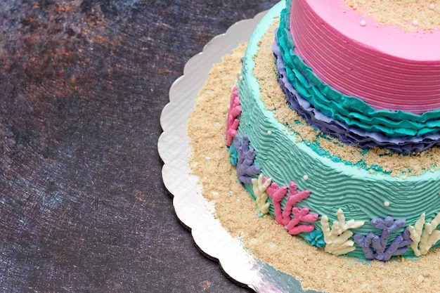 Cake decorated as painting with spatula. Colorful cake on cement table.