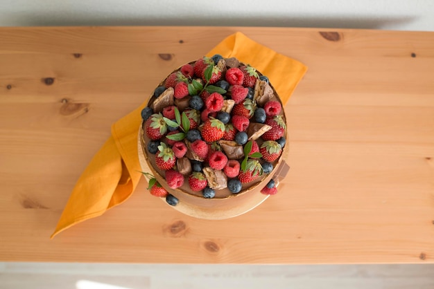 Cake decorated with chocolate and berries, top view