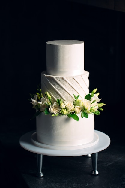 Cake is decorated with flowers on dark