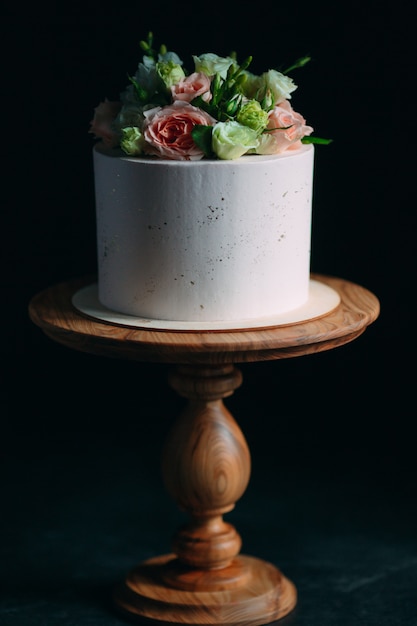 Cake is decorated with flowers on dark