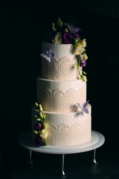 Cake is decorated with flowers on dark