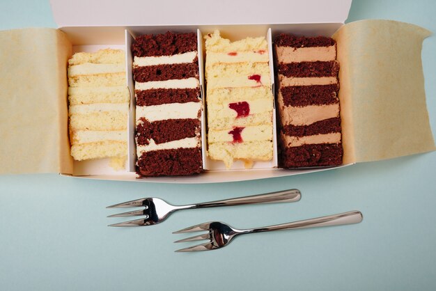 Cake slices in a box with forks