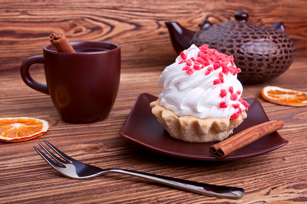 Cake and tea with cinnamon on a wooden background. selective focus