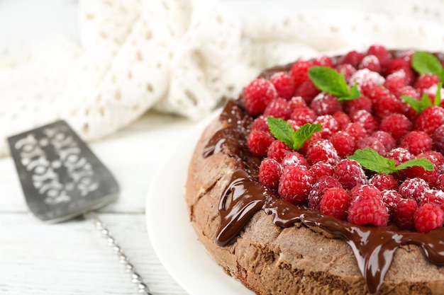 Cake with Chocolate Glaze and raspberries on color wooden background