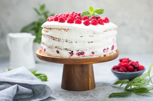 Cake with cream mousse and raspberry filling on a round stand