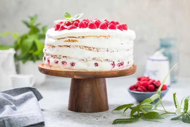 Cake with cream mousse and raspberry filling on a round stand