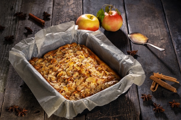 cake with nuts in a baking dish stands on a wooden background