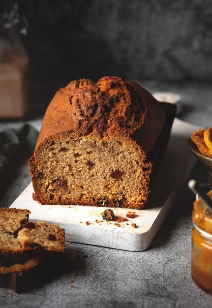 Cake with raisins on a wooden board, homemade baked goods with dried fruits