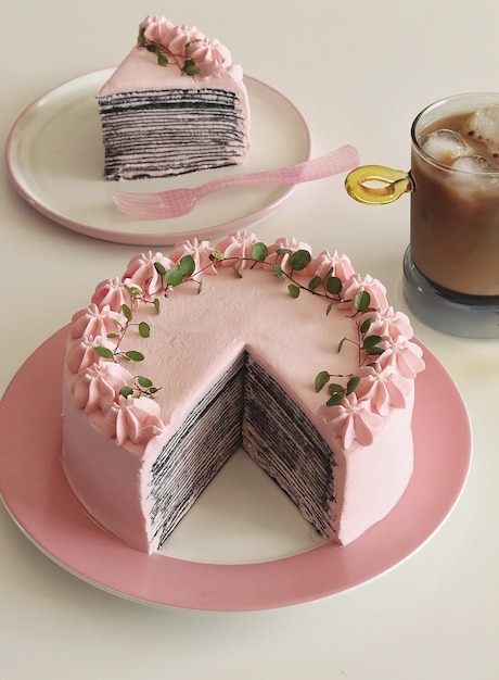 A cake with a slice cut out of it and a cup of coffee on the table.