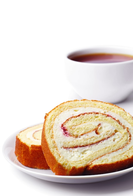 Cakes in a plate and cup of tea closeup on white