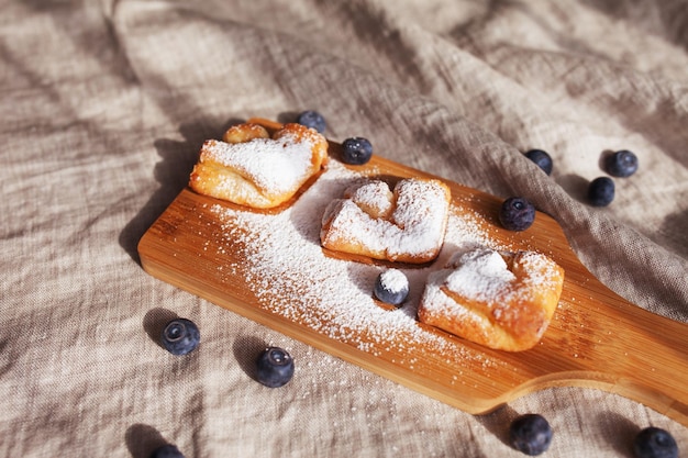 Cakes with blueberries sprinkled with icing sugar on a wooden background Top view Healthy eating Breakfast idea for children and adults