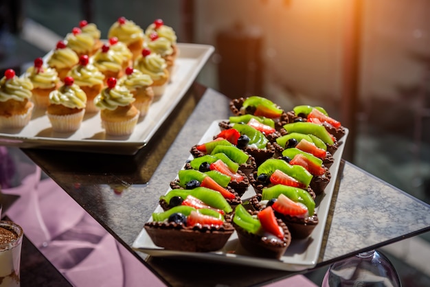 Cakes with fresh fruit and berries on the holiday table