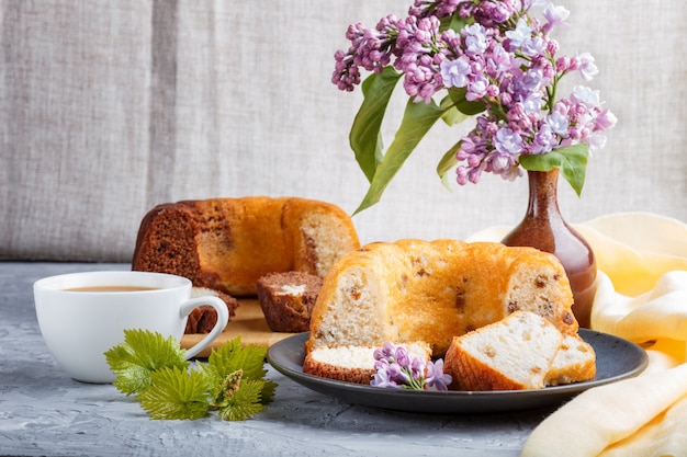 Cakes with raisins and chocolate and a cup of coffee on a gray concrete background 