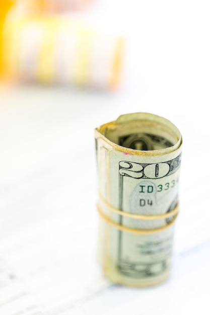 Calculating income tax return with folded cash on a table.