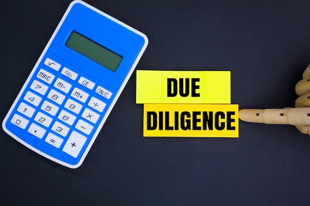 Photo calculator and colored paper with the word due diligence business management concept