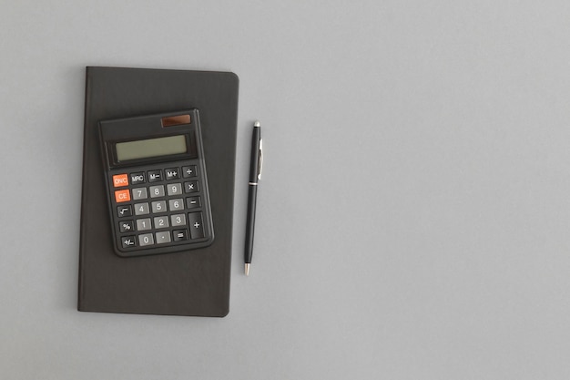 Calculator notebook pen on gray background Back to school