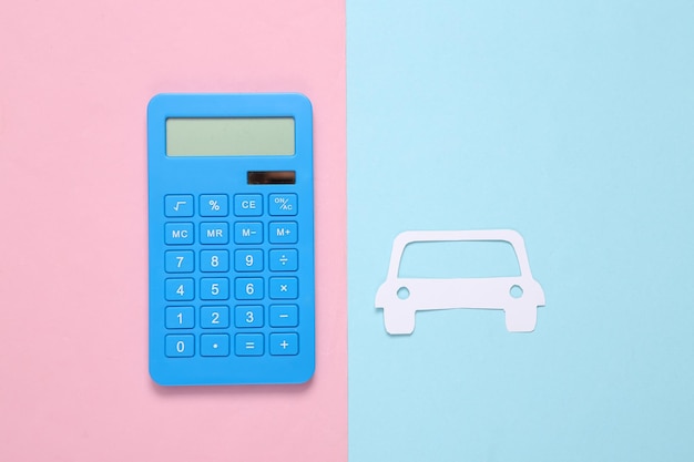 Calculator and papercut car on a bluepink background