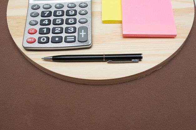 Calculator and pen near notepad on desk office