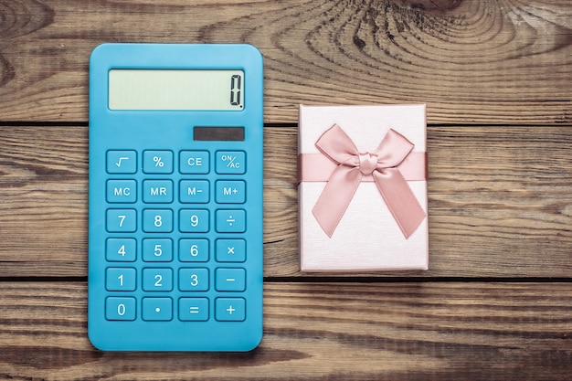 Calculator with a gift box on a wooden