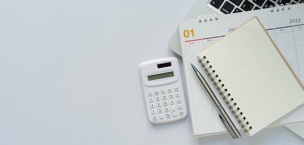 Calculator with notebook calendar and laptop office supplies on white color background