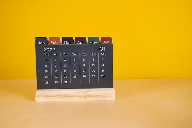 A calendar on table against yellow background