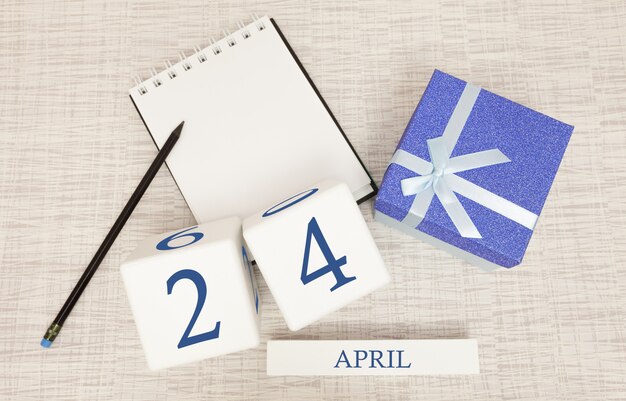 Photo calendar with trendy blue text and numbers for april 24 and a gift in a box.