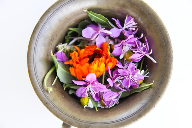 Calendula and fireweed plants prepared for drying Medicinal herbs and flowers in a cooper mortar