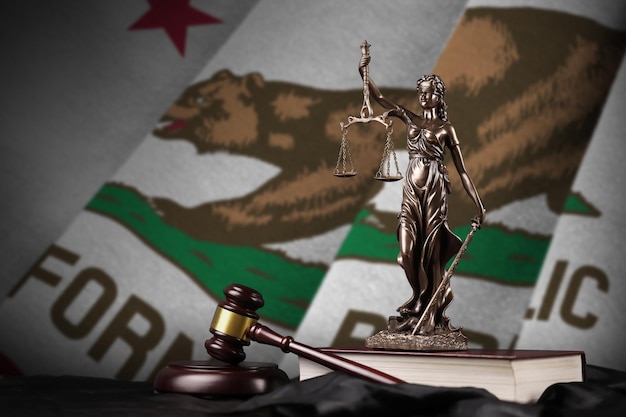 California US state flag with statue of lady justice constitution and judge hammer on black drapery Concept of judgement and guilt