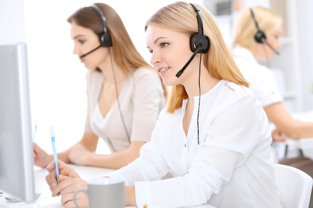 Call center. Focus on beautiful woman in headset.