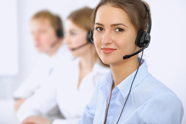 Call center. Focus on beautiful woman in headset.