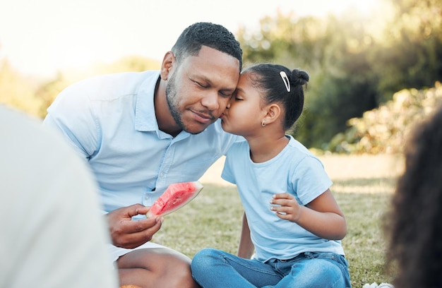 Call it a tribe call it a family Shot of a daughter kissing her dad at a picnic