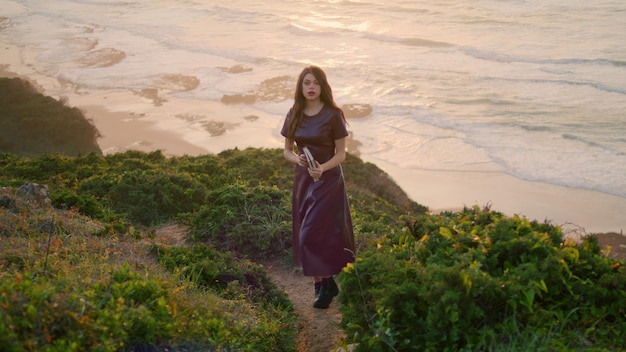 Calm brunette relaxing seashore standing hill holding book girl posing nature