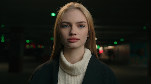 Calm lady caucasian woman stand alone on dark parking background focused blonde girl looking at