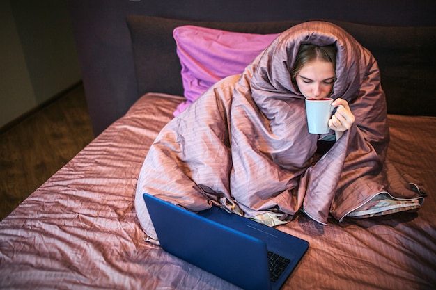 Calm and peaceful young woman sits on bed