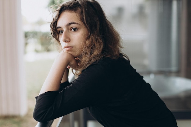 Calm pretty teenager girl on the balcony looking away